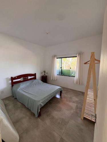 una camera da letto con un letto e una finestra di Apartamentos e Suites Casa Verde a Búzios