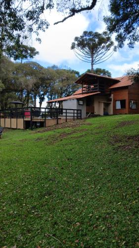 ein Gebäude mit einer Rasenfläche vor einem Haus in der Unterkunft Pousada Caminho do Lago in Rio Rufino