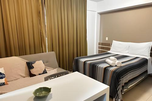 a hotel room with a bed and a couch at Saint Moritz, bom gosto e estilo in Brasilia