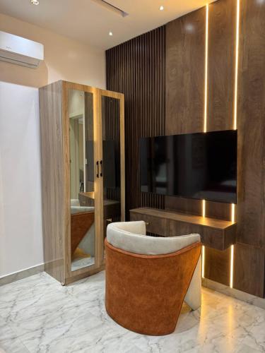 Una sala de estar con un televisor y una silla. en Pavilion Heights, en Lagos