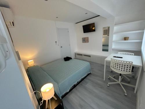 a small bedroom with a bed and a desk at Rooms Mármol, junto a Puerta Toledo in Madrid
