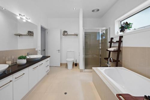a bathroom with two sinks and a tub and a shower at Barbro Warrnambool in Warrnambool