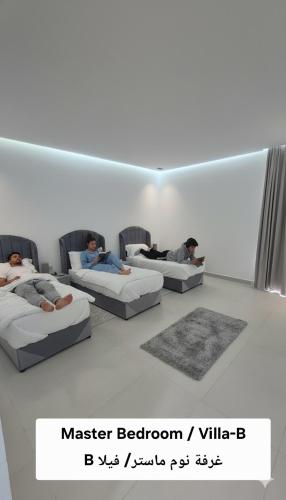 3 Personen, die in einem Zimmer auf Betten liegen in der Unterkunft شاليه منتجع جوري حتا الخاص -J3- Jory Hatta Private Resort Chalet in Hatta