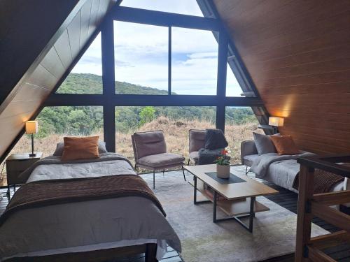 a bedroom with two beds and a large window at Cabañas Piedra del Risco in Alto Boquete