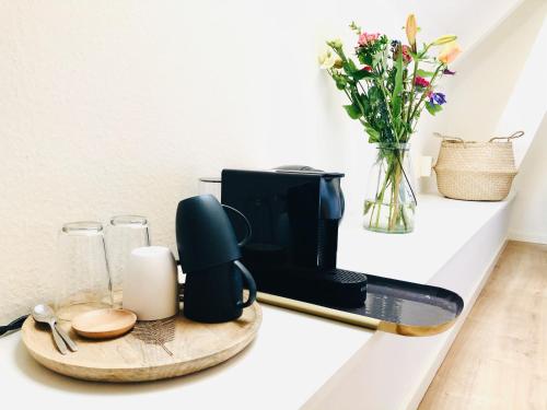 eine schwarze Kaffeemaschine auf einer Theke mit einer Vase mit Blumen in der Unterkunft B&B in woonboerderij vlakbij Lemmer in Rutten