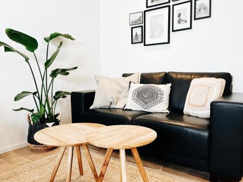 ein schwarzes Ledersofa mit einem Couchtisch aus Holz im Wohnzimmer in der Unterkunft B&B in woonboerderij vlakbij Lemmer in Rutten