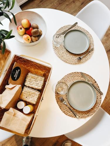 un tavolo bianco con due piatti e un vassoio di cibo di B&B Whanau, vlakbij Lemmer a Rutten