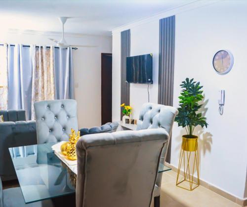 a living room with blue chairs and a glass table at Tu rincon Caribeño in San Isidro