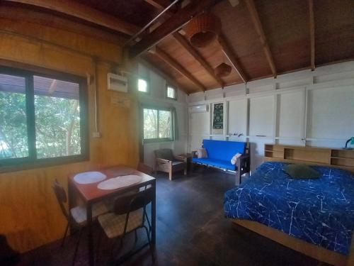 a bedroom with a bed and a table and a couch at Cabaña monoambiente Yasyry in Las Toscas
