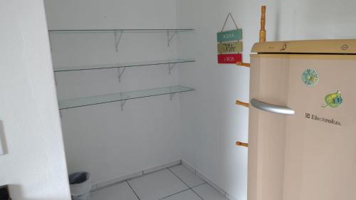een koelkast in een keuken met een plank bij Pousada Casa da Praia in Passo de Torres