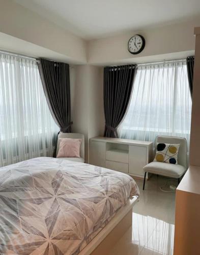 a bedroom with a bed and a chair and a clock at Indra Homs in Pabuaran Lima