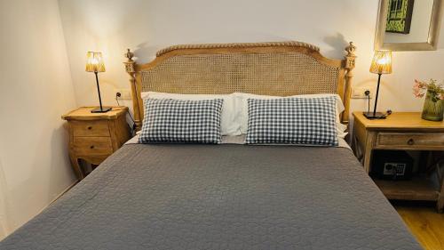 ein Schlafzimmer mit einem Bett mit zwei Nachttischen und zwei Lampen in der Unterkunft Apartamentos Alcazar de Baeza in Baeza