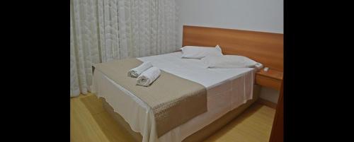 a bed with towels on it in a room at Hotel Ampiezza in Curitiba