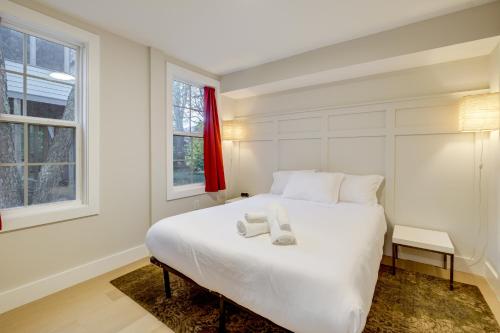 Un dormitorio con una cama blanca con dos toallas encima. en Walk to Metro and Dtwn Silver Spring! Sleek Apt, en Silver Spring