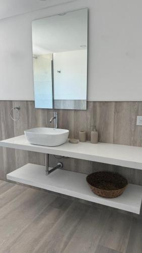 une salle de bain avec un lavabo et un miroir dans l'établissement Increíble Dpto en Costa del Este con vista al mar, à Costa del Este