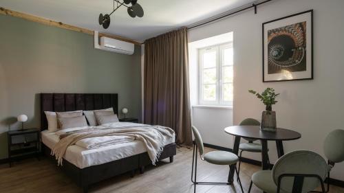une chambre avec un lit, une table et des chaises dans l'établissement Apartamenty Old House Casino Koszarowa 1, à Wrocław