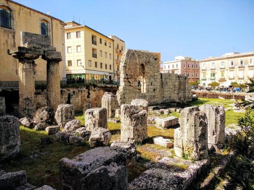 um conjunto de ruínas em uma cidade com edifícios em Apollonion HH above Apollo's temple Ortygia em Siracusa