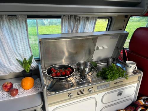 Una cocina en una casa rodante con frutas y verduras. en rent a campervan vw t3 azul in Algarve Portugal, en Bicas