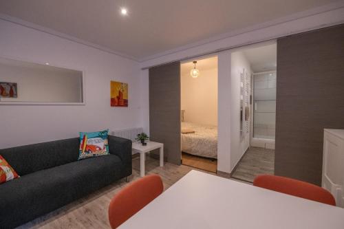 a living room with a couch and a table and a bedroom at Studio central 002B in Saint-Étienne