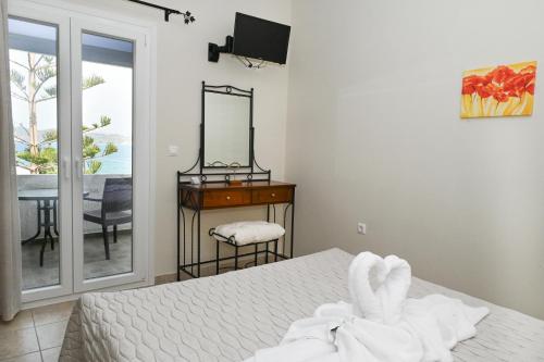 a bedroom with a bed with a mirror and a table at Akrothalassia in Adamantas
