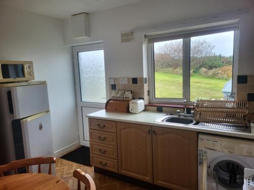 a kitchen with a sink and a window at Ard A Mhaoire in Glendorragha