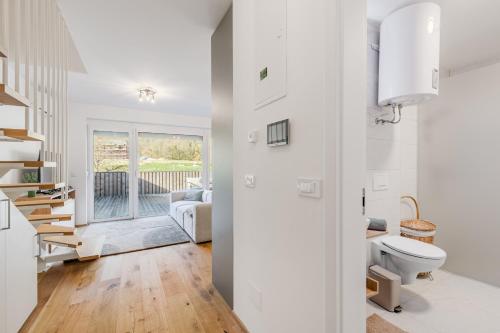 a white bathroom with a toilet and a staircase at Family Apartment Bovec with Free Parking in Bovec