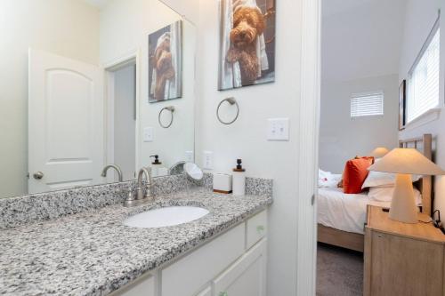 a bathroom with a sink and a bedroom with a bed at Fenced Backyard - Walk to Old Town Lewisville in Lewisville