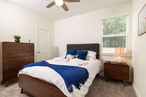 a bedroom with a large bed with blue and white sheets at Fenced Backyard - Walk to Old Town Lewisville in Lewisville