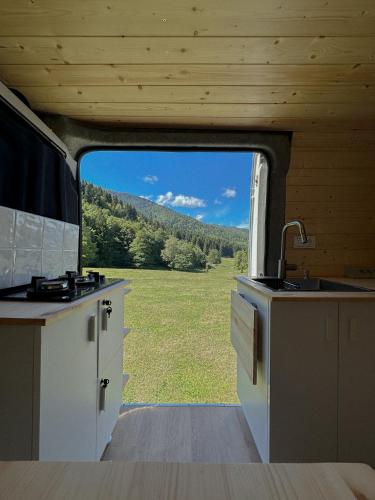 a kitchen with a view of a field through a window at campers georgia in Kutaisi