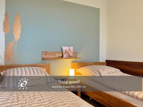 two beds sitting next to each other in a room at Ferienwohnung mit Nordseeblick! de Swolk in Dorum Neufeld