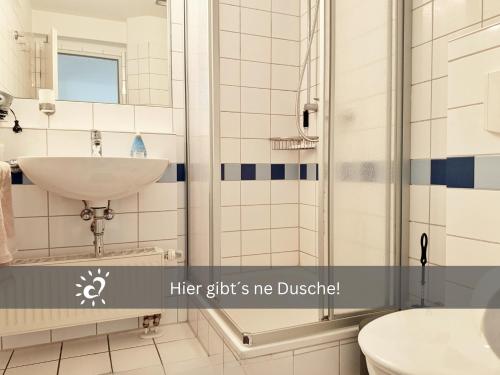 a bathroom with a sink and a shower at Ferienwohnung mit Nordseeblick! de Swolk in Dorum Neufeld