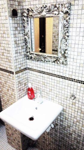 a bathroom with a white sink and a mirror at Apartment in city center in Daugavpils