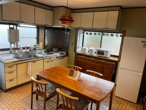 a kitchen with a wooden table and chairs in it at 信の宿 花巻 in Hanamaki