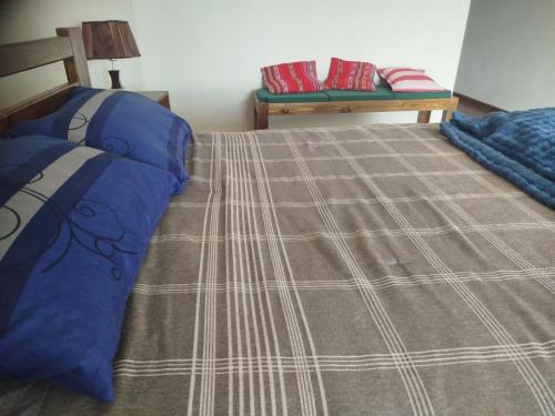 ein Schlafzimmer mit einem Bett mit einer Decke in der Unterkunft La Casa de Mamá Nelly in Sucre