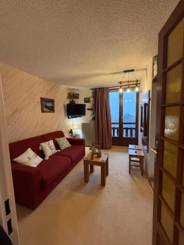 un salon avec un canapé rouge et une table dans l'établissement Montagne, à Risoul