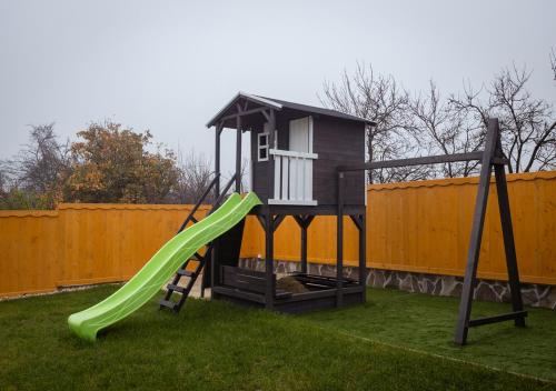 a playground with a slide and a play house at Lebujos Vendégház in Boldogkőváralja