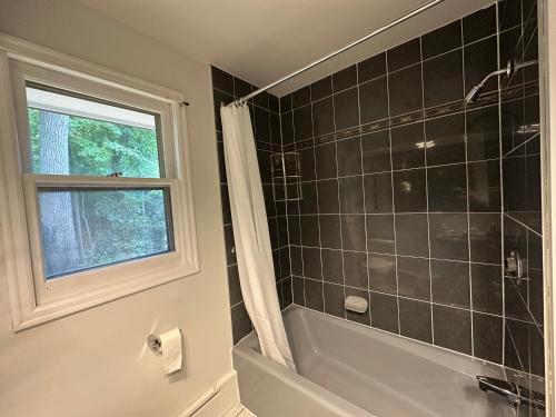 a bathroom with a shower and a tub and a window at Modern Private Room with Bessarion Subway North York in Toronto