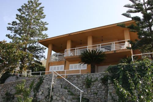 una casa en una colina con árboles y escaleras en Lomarchi Holiday Home en Carini