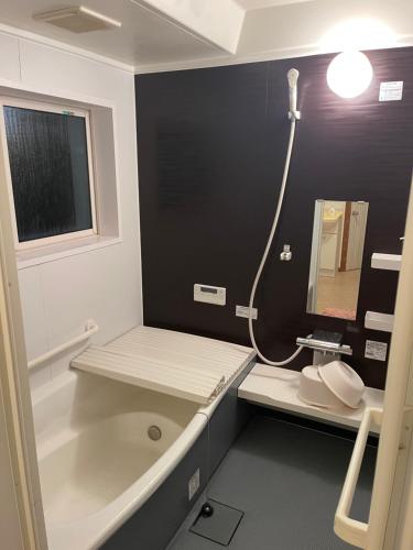 a bathroom with a tub and a sink and a mirror at 信の宿 花巻 in Hanamaki