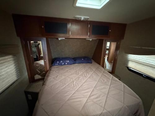 ein kleines Schlafzimmer mit einem Bett in einem kleinen Zimmer in der Unterkunft Camper Adventure in Livingston