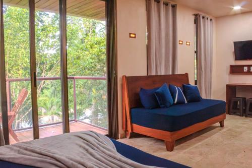 a bedroom with a bed and a large window at Loft Colibrí - Santuario Apartments in Chemuyil