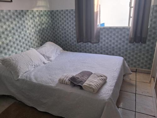 - un lit avec 2 couvertures et 2 serviettes dans l'établissement Hostel mi casa su casa, à Poços de Caldas