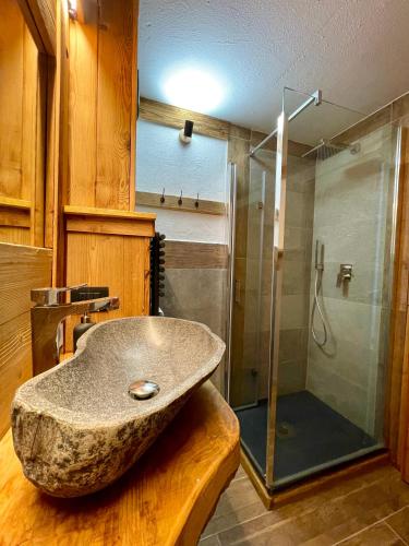 ein Badezimmer mit Steinwaschbecken und Dusche in der Unterkunft White Relax in Pila