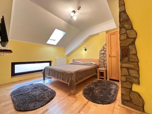 ein Schlafzimmer mit einem Bett und einer Steinwand in der Unterkunft Vâlceaua Zânelor in Stațiunea Climaterică Sâmbăta