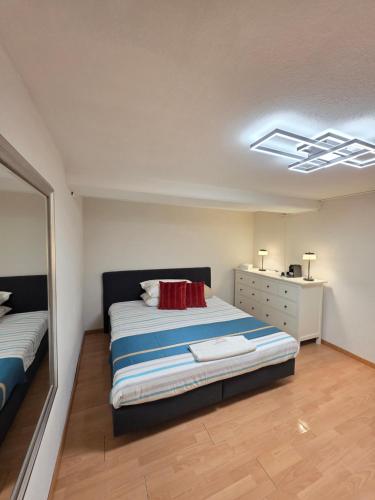 a bedroom with a bed and a dresser in it at Hello Zimmer in Brügg