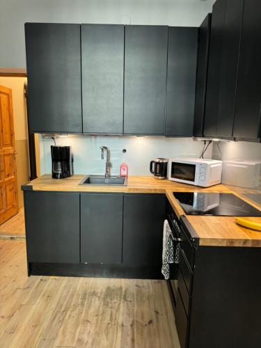 a kitchen with black cabinets and a sink at Melrose Place in Helsinki