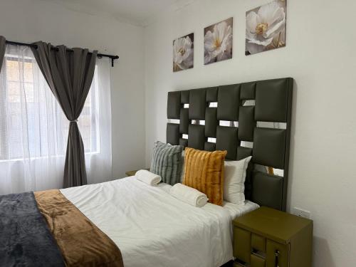 ein Schlafzimmer mit großem Bett und Fenster in der Unterkunft Hippoville in Mbabane