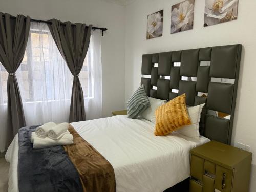 ein Schlafzimmer mit großem Bett und Fenster in der Unterkunft Hippoville in Mbabane