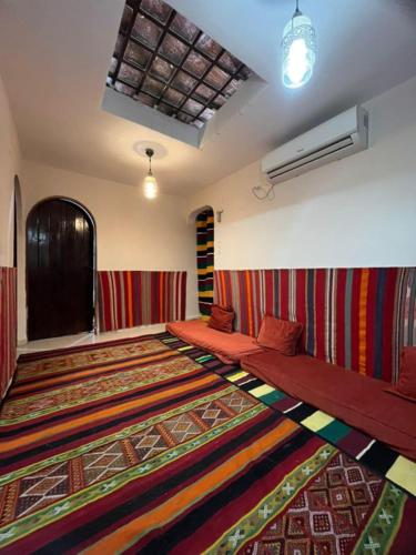 Maison authentique au cœur des oasis في غرداية: غرفة بها سجادة كبيرة على الأرض