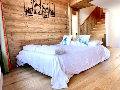 ein Schlafzimmer mit einem weißen Bett und einer Holzwand in der Unterkunft White Relax in Pila